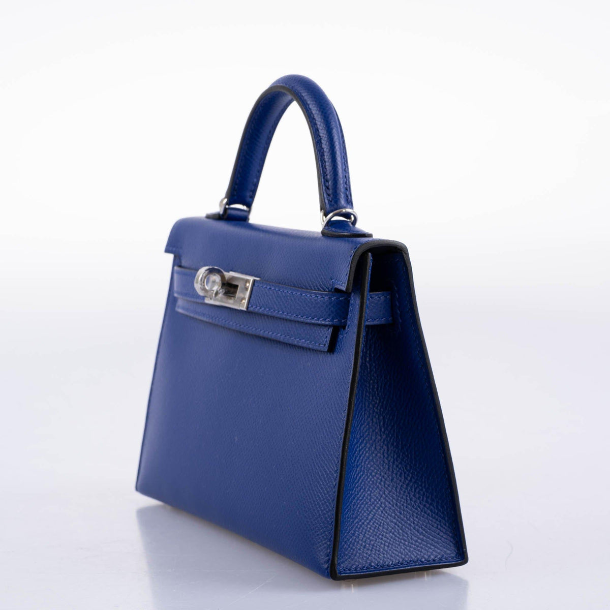 Blue handbag with a silver clasp on a white background